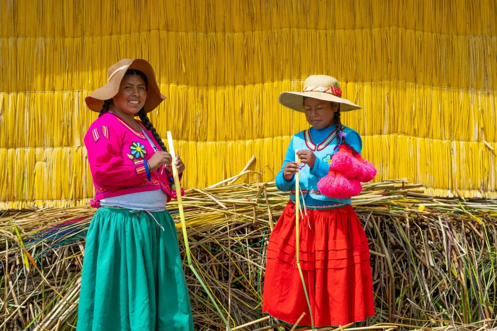 Mujeres uro trabajando la totora frente a su casa